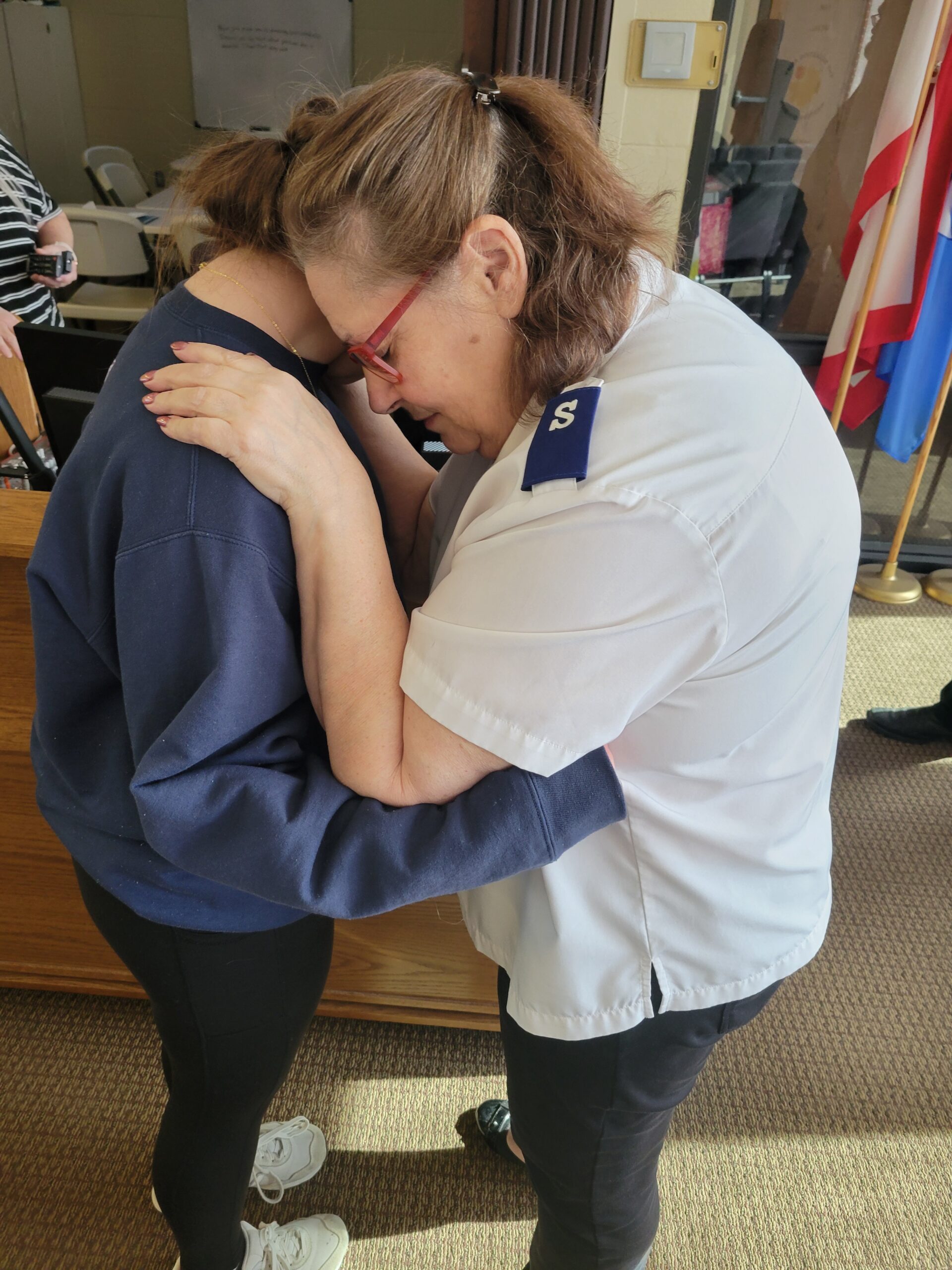 Mentor Donna Roberts prays with her mentee, Abby